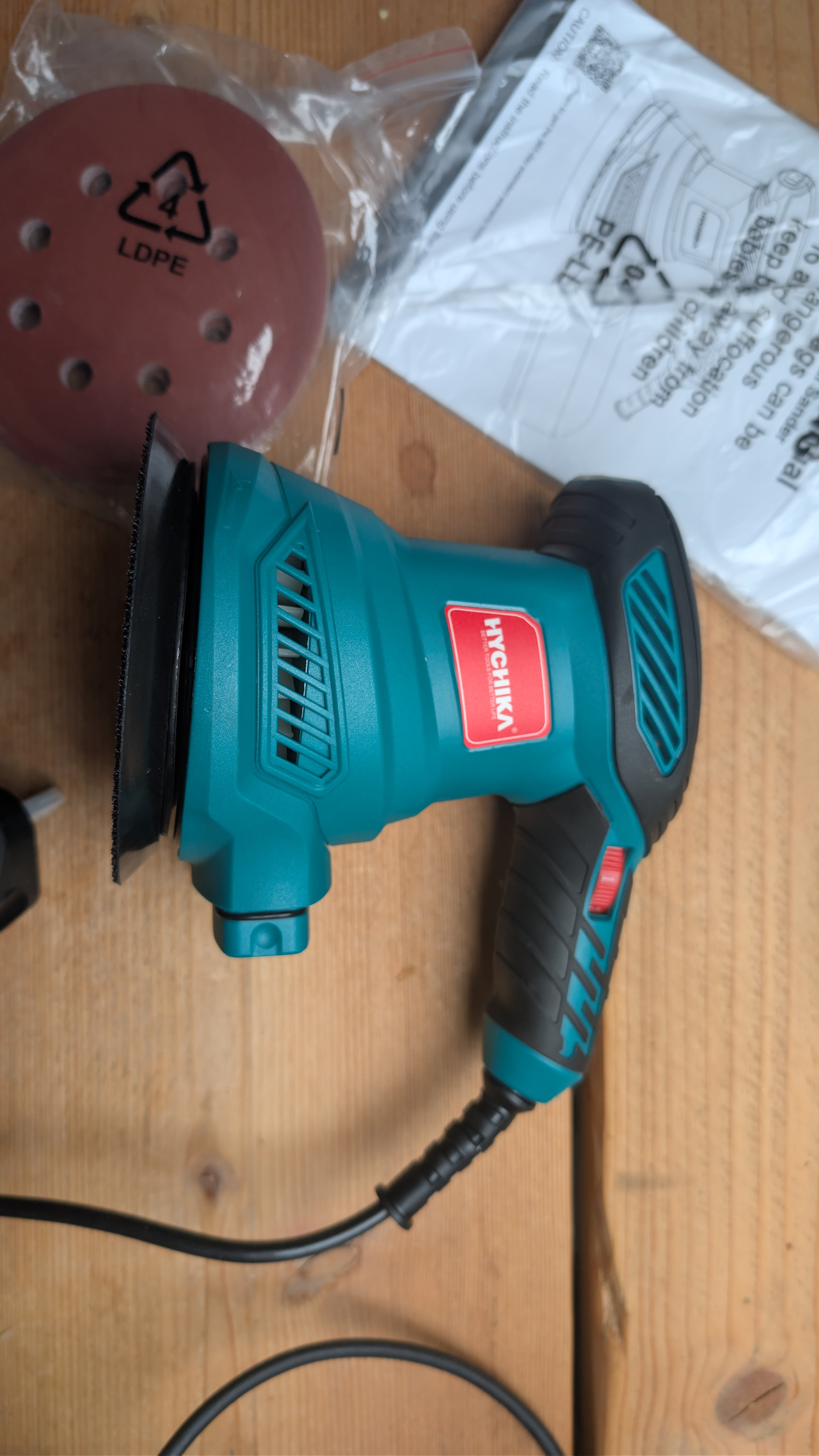 Side view of HYCHIKA orbital sander showing ergonomic grip and 6-speed control dial